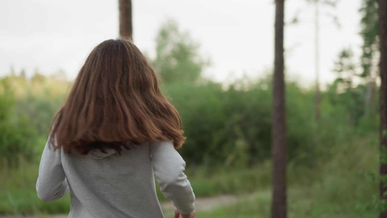 저녁에 숲 속 깊은 곳에서 달리는 여자, 신선한 공기에서 심장 운동을 끝내는 경로를 향해 움직이는 여자, 자연에서 신체 모양을 개선하는 여자.