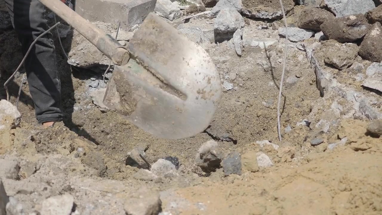 Trabajador excavando tierra con una pala en una obra de construcción