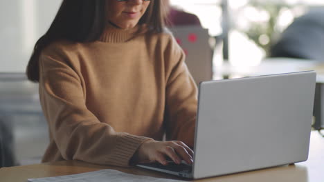 Trabajadora-De-Oficina-Escribiendo-En-La-Computadora-Portátil-En-El-Escritorio