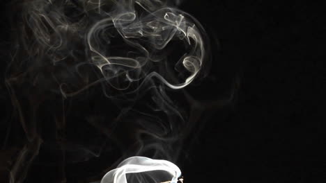 primer plano de humo de incienso que sube contra un fondo negro 2