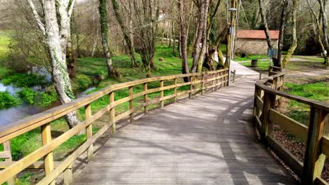 pov walking along empty elevated wooden promenade in local park at ordes, coruna