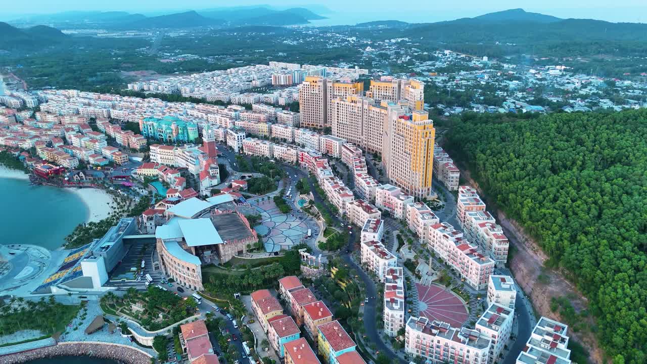 High altitude drone shot of Phu Quoc's Sunset Town, Vietnam. Faux Italian architecture, vibrant colors, and modern cityscape.