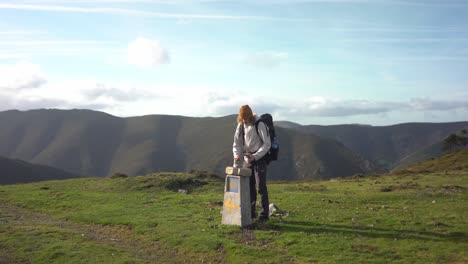 Pilgrim-rock-stacking-on-yellow-arrow-Camino-de-Santiago-stone-sign