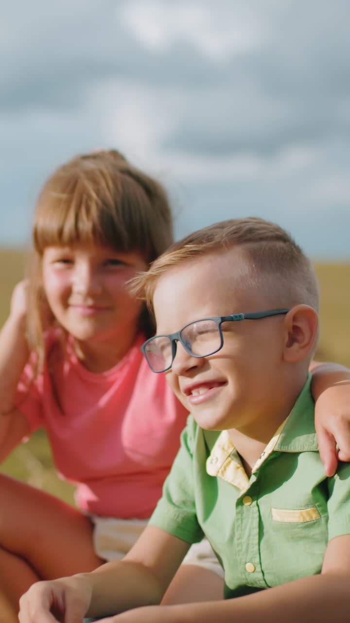 hermano y hermana agachados al aire libre en la cálida luz del sol, compartiendo un momento cercano de hermanos, la hermana sostiene afectuosamente a su hermano mientras disfrutan del tranquilo entorno rural