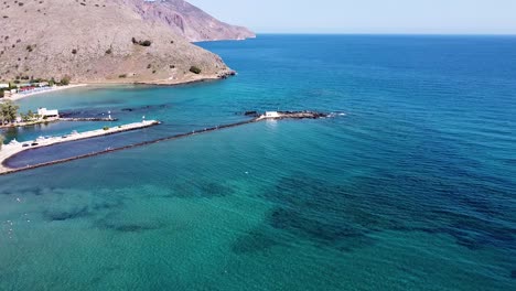 Crete-landscape-and-small-white-chapel-in-seascape,-aerial-view