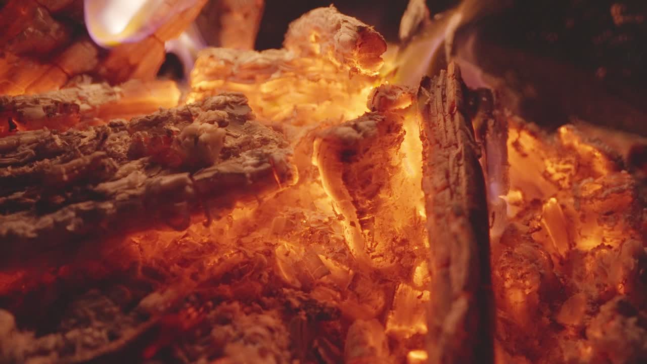 Crackling wood in a glowing bed, amber flames where stories are fed