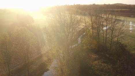 aerial view descending alongside the river stour, kent, uk with a stunning sunrise illuminating the mist