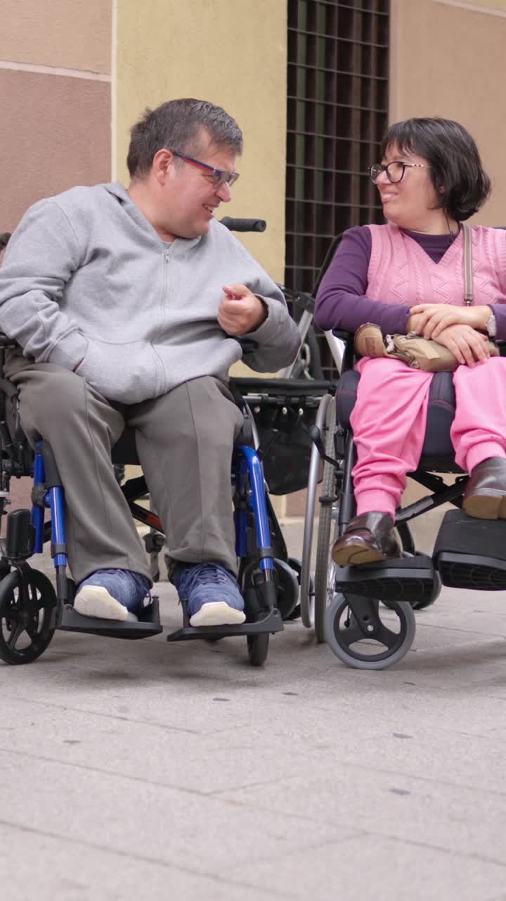 Amici in sedia a rotelle che chiacchierano animatamente all'aperto