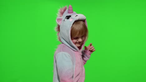 Little-blonde-child-girl-smiling,-dancing,-celebrating-in-unicorn-pajamas-costume-on-chroma-key