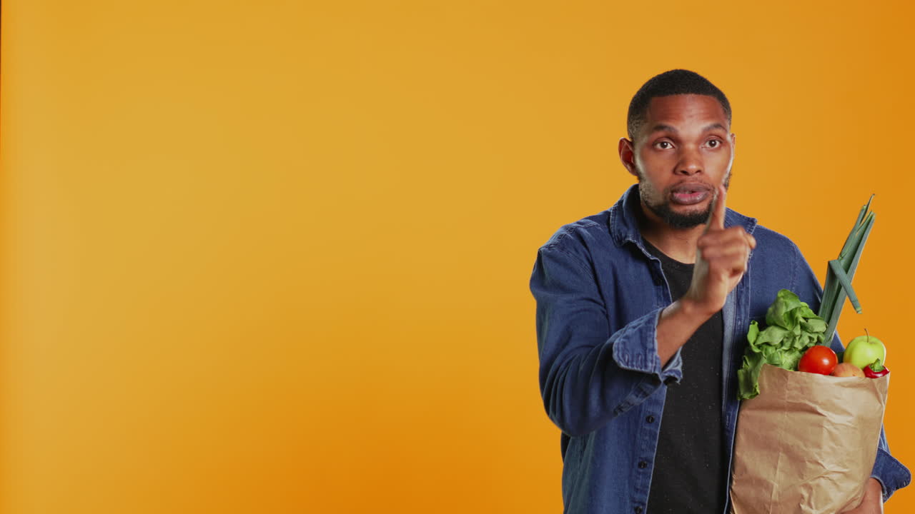 African american secretive guy doing mute hush gesture with finger over lips