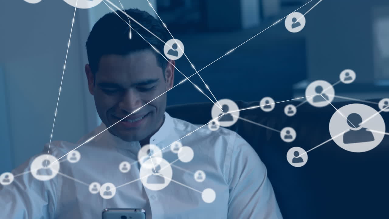 Animation of network of profile icons against happy biracial man using smartphone at office