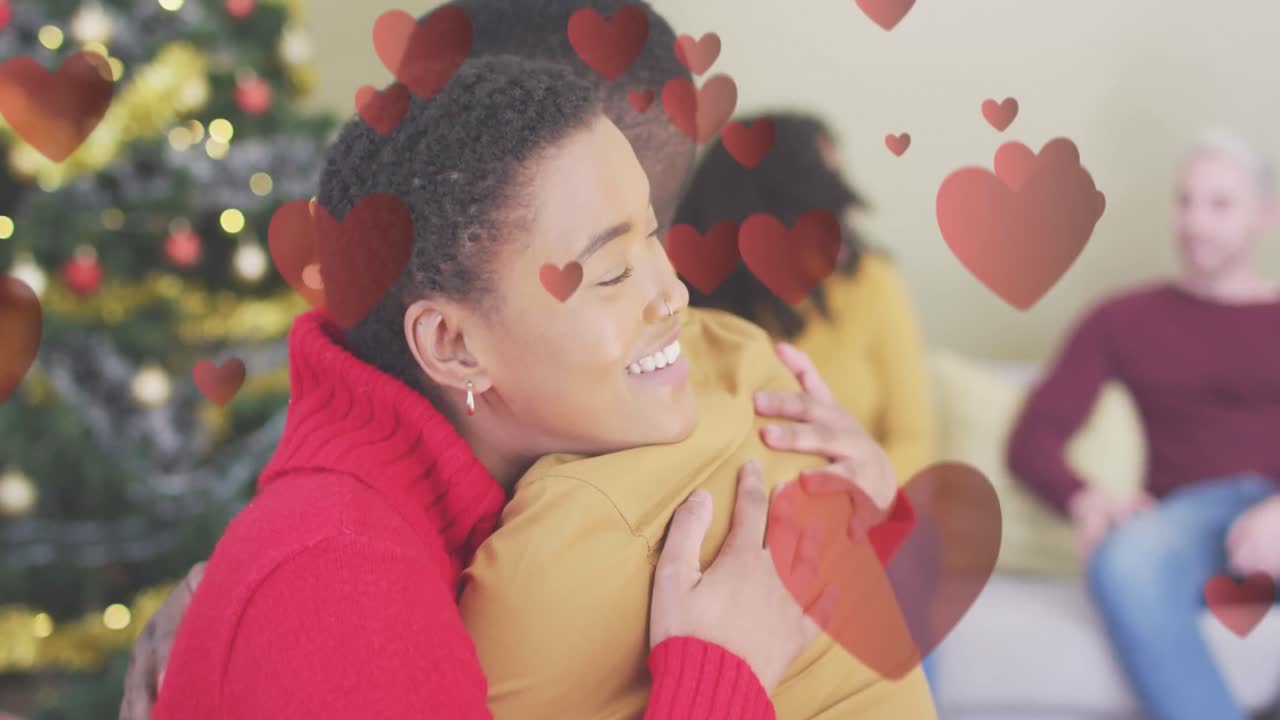 animación de los corazones sobre una pareja afroamericana abrazándose en navidad.