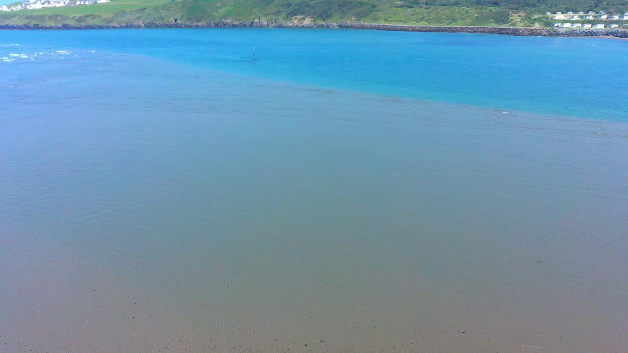 새가 가로질러 날아가는 얕은 바다의 공중 바깥쪽 샷