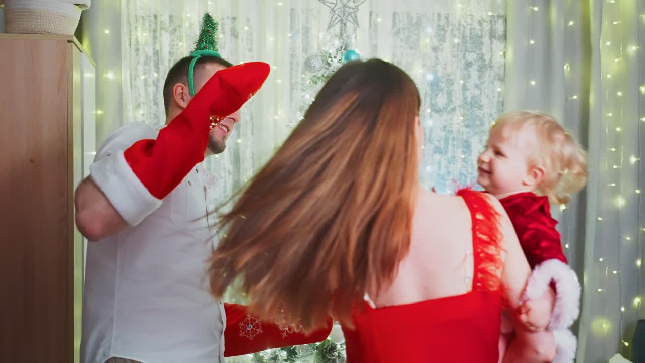 Cheerful family wearing festive clothing bonding together near decorated christmas tree, playing with oversized holiday socks and sharing joyful moments