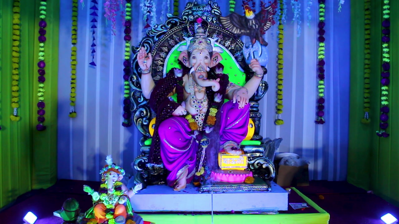 Ganpati idol beautifully decorated in colorful pandal with flowers and lights. Ideal for stock footage showcasing Indian traditions, spirituality, Ganesh Chaturthi and cultural celebration.