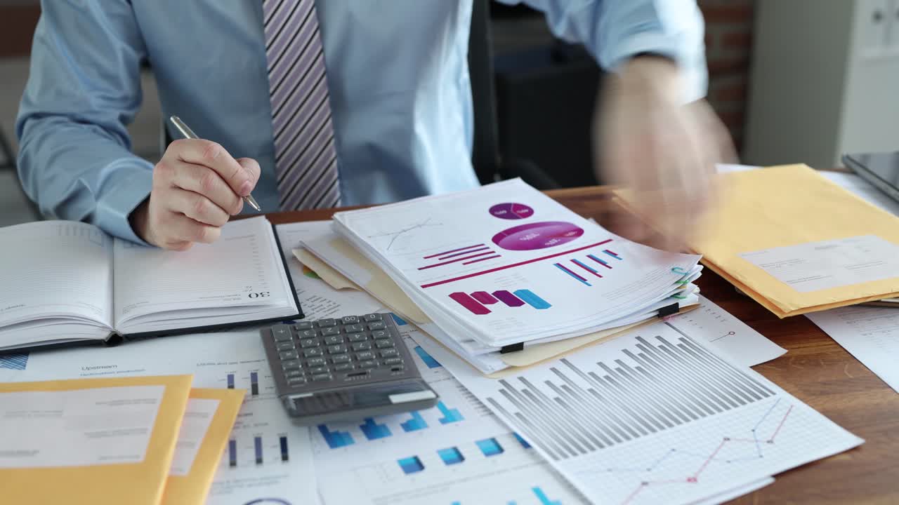 A person working with financial documents and charts in an office setting