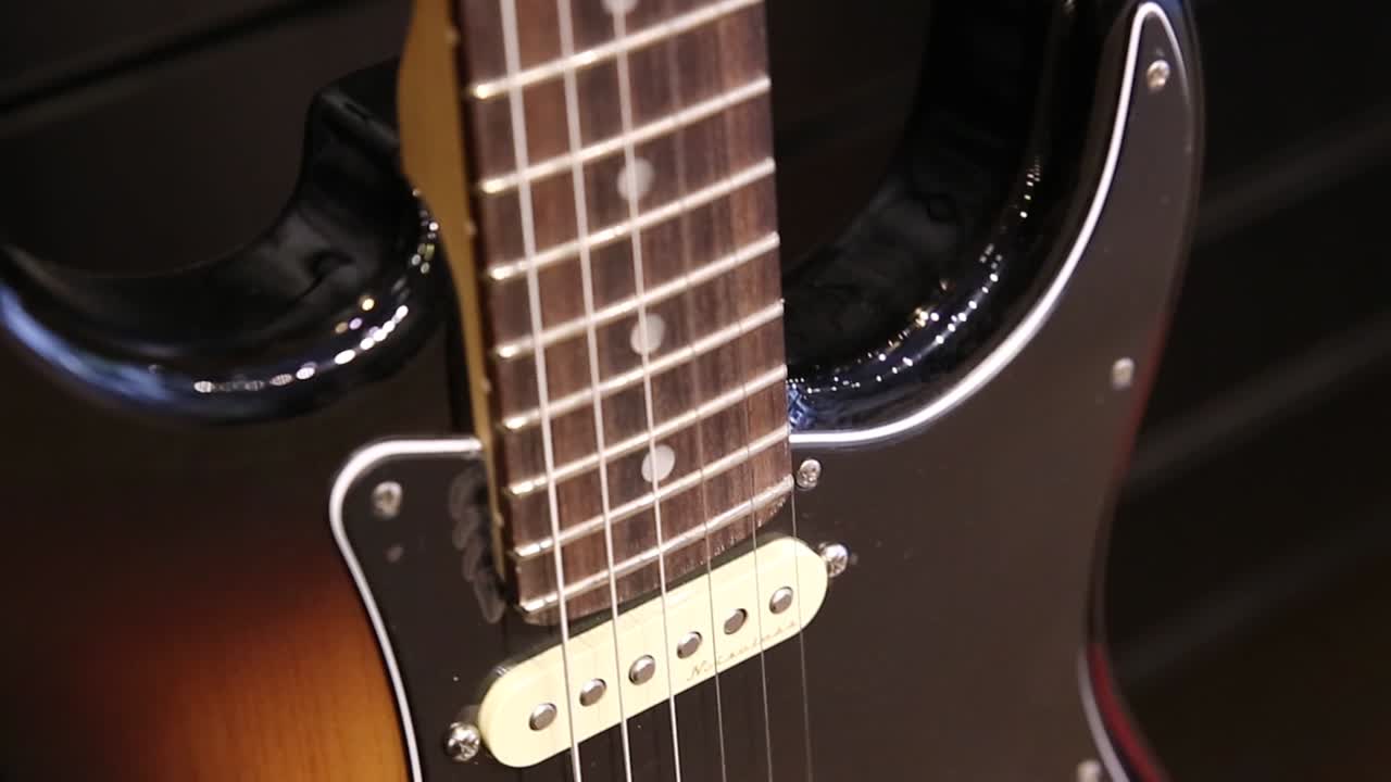 Chitarra elettrica professionale marrone-gialla, movimento dal basso verso l'alto