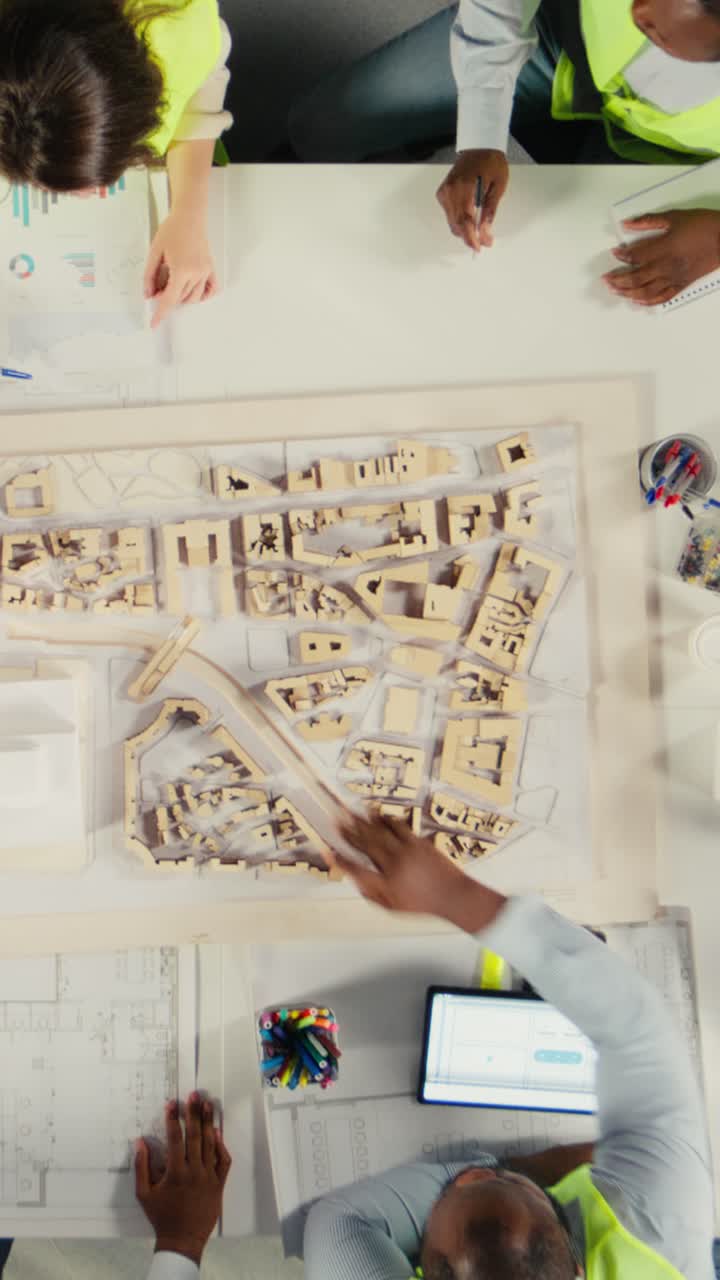 Vertical Video Top down view zoom out of developers and architects in business meeting