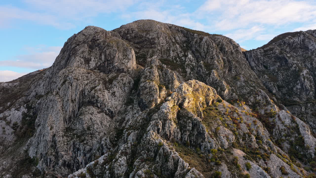 Vista aerea da drone di aspre scogliere di montagna grigie, illuminate dalla delicata luce del sole mattutino