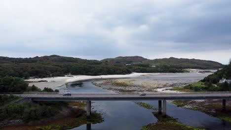 Verkehr,-Der-über-Die-Morar-River-Bridge-In-Der-Nähe-Von-Silver-Sands-Beach-In-Morar,-Westküste-Schottlands-Fährt---Luftdrohne-4k-Hd-Steigt-Auf