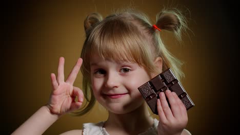 niña con barra de chocolate mostrando el signo de gesto ok, adolescente satisfecha haciendo caras, sonriendo