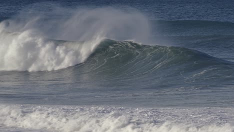 surfer rides into a barrel created by a huge wave that overwhelms him