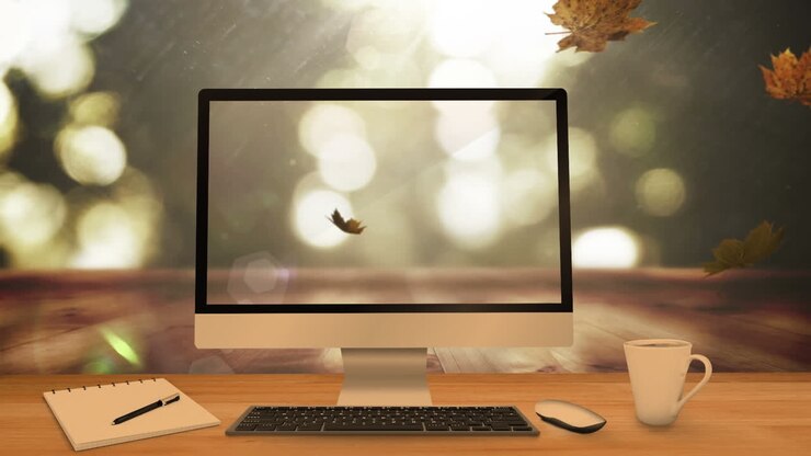 Animation von fallenden Blättern über Laptop, Computer und Schreibtisch.