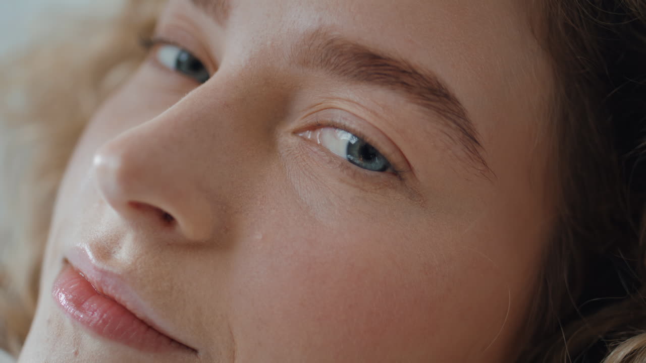 Portrait pretty woman face gazing camera. Smiling lady with blue eyes