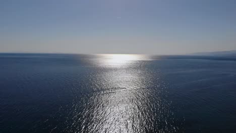 aerial upward flight over marmara sea when sunlights touch on sea surface, balikesir, turkey