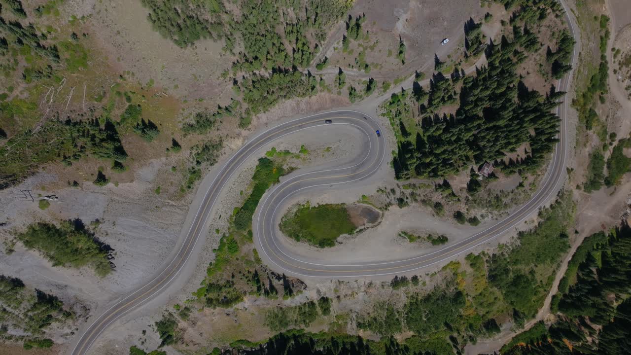 Dramatic aerial of steep mountain switchbacks cutting by rugged Colorado terrain, Million Dollay Highway Colorado USA