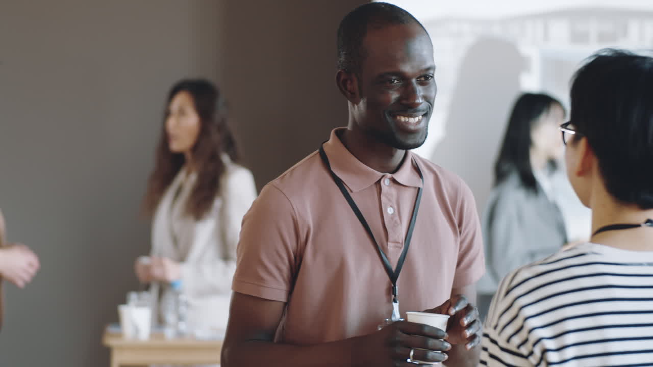 African American Man Talking with Female Colleague on Business Event