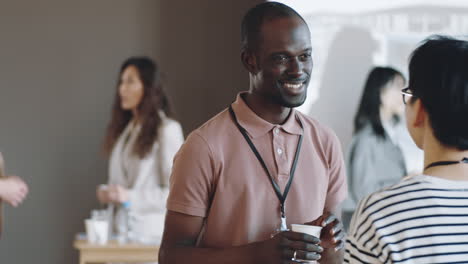 african american man talking with female colleague on business event