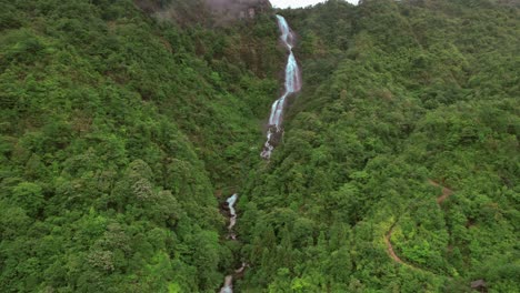 Stream-of-water-down-the-hills-in-Sa-Pa,-Vietnam,-captured-by-a-drone,-finishing-in-the-road-near-by