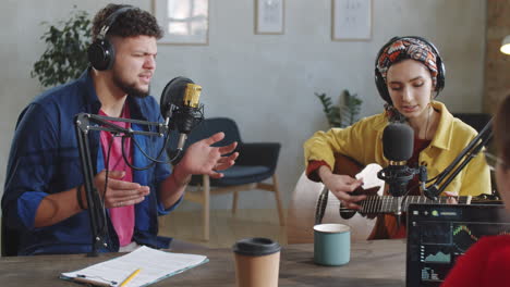 Mann-Singt-Im-Mikrofon-Und-Frau-Spielt-Gitarre-Im-Aufnahmestudio