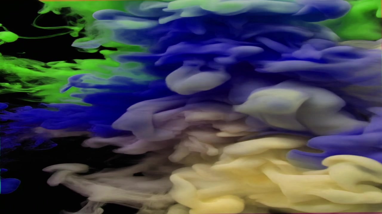 Nuvole d'inchiostro colorate vorticose nell'acqua su sfondo nero