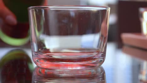 pouring water into a glass on a shining table