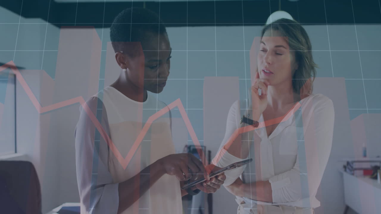 Discussing data, two businesswomen using tablet with financial animation overlay