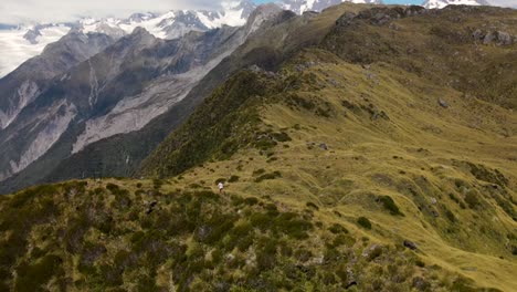 Junge-Frau-Mit-Kamera-Geht-Auf-Berggipfel---Luftaufnahme-Einer-Malerischen-Alpenlandschaft-Mit-Gletschern-Und-Schneebedeckten-Gipfeln