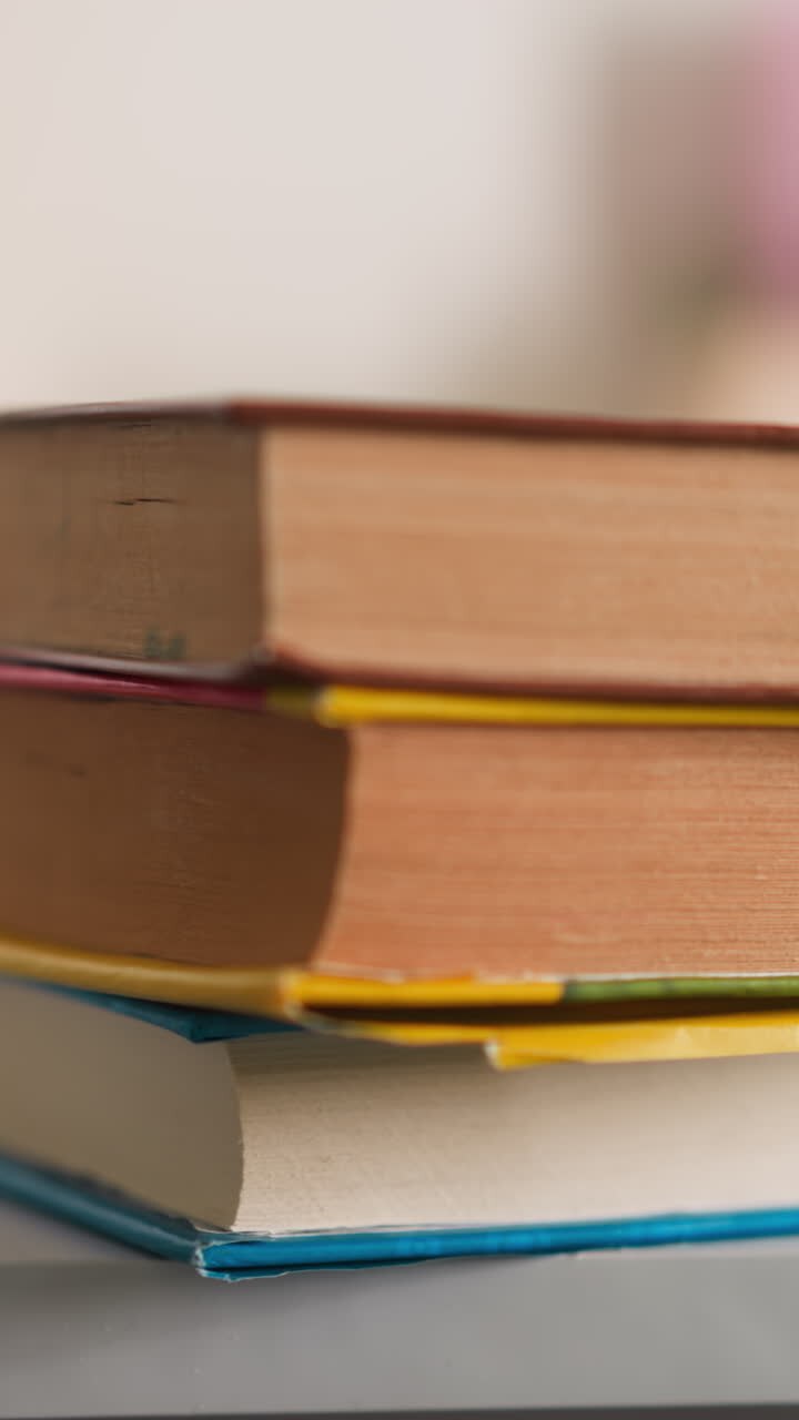 Little girl puts textbooks heap on desk with school supplies at home closeup. Schoolgirl prepares literature for homework lesson at table in children room