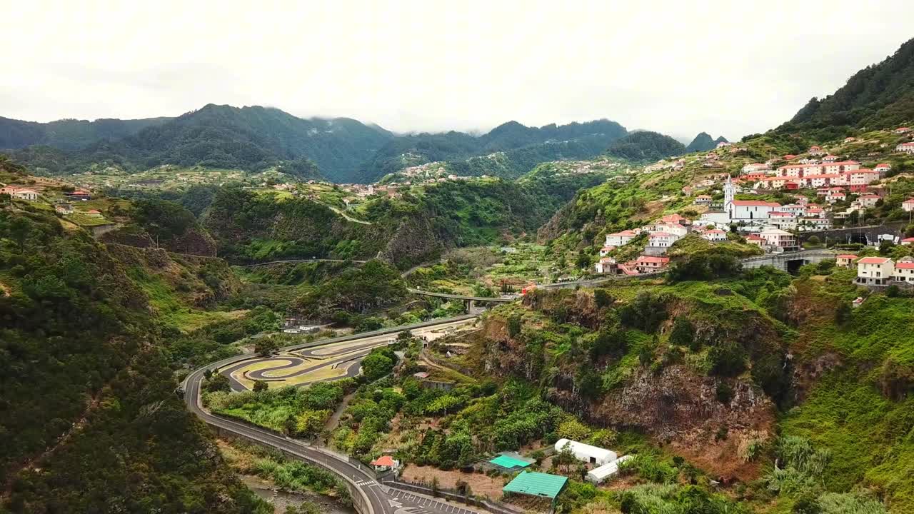 Aerial view showcasing the valley, surrounding the charming village nestled amidst the dramatic slopes, creating a tranquil scene under a cloudy sky in Faial civil parrish in Madeira Island, Portugal