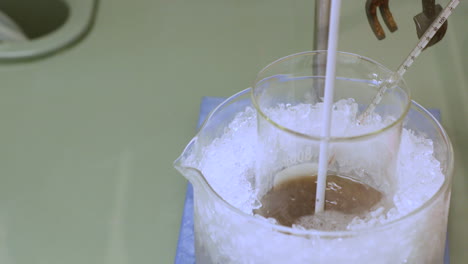 mixed chemical solutions cooled with ice for experiment use in coimbra university, portugal - high angle, close up