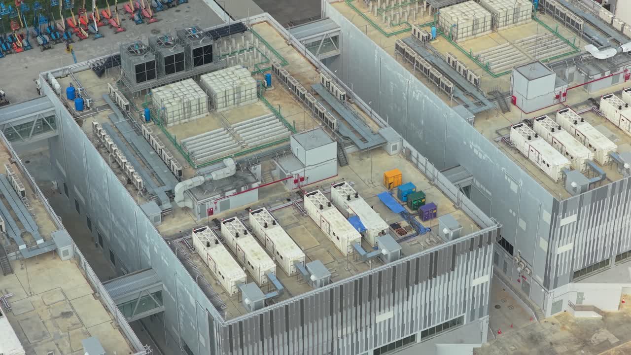 High angle view showcasing a large scale data center facility. The building's roof is equipped with advanced cooling and power systems