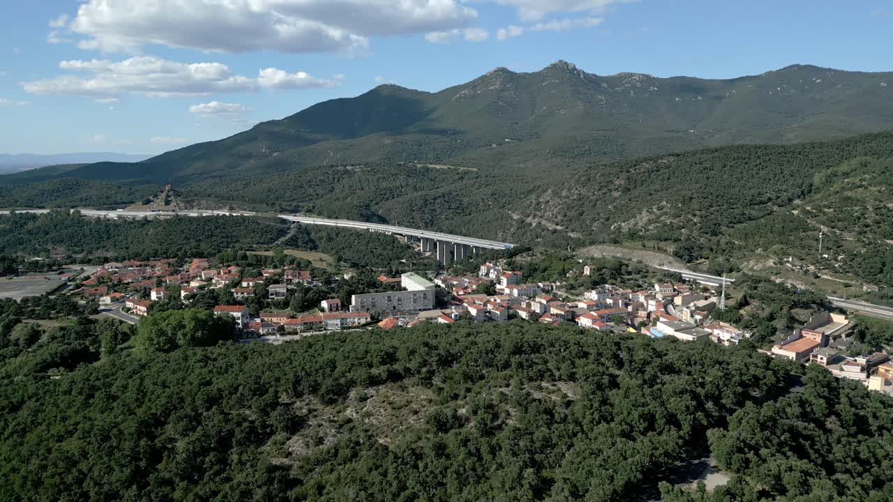 Aerial View of a Village in the Mountains with a Highway Bridge