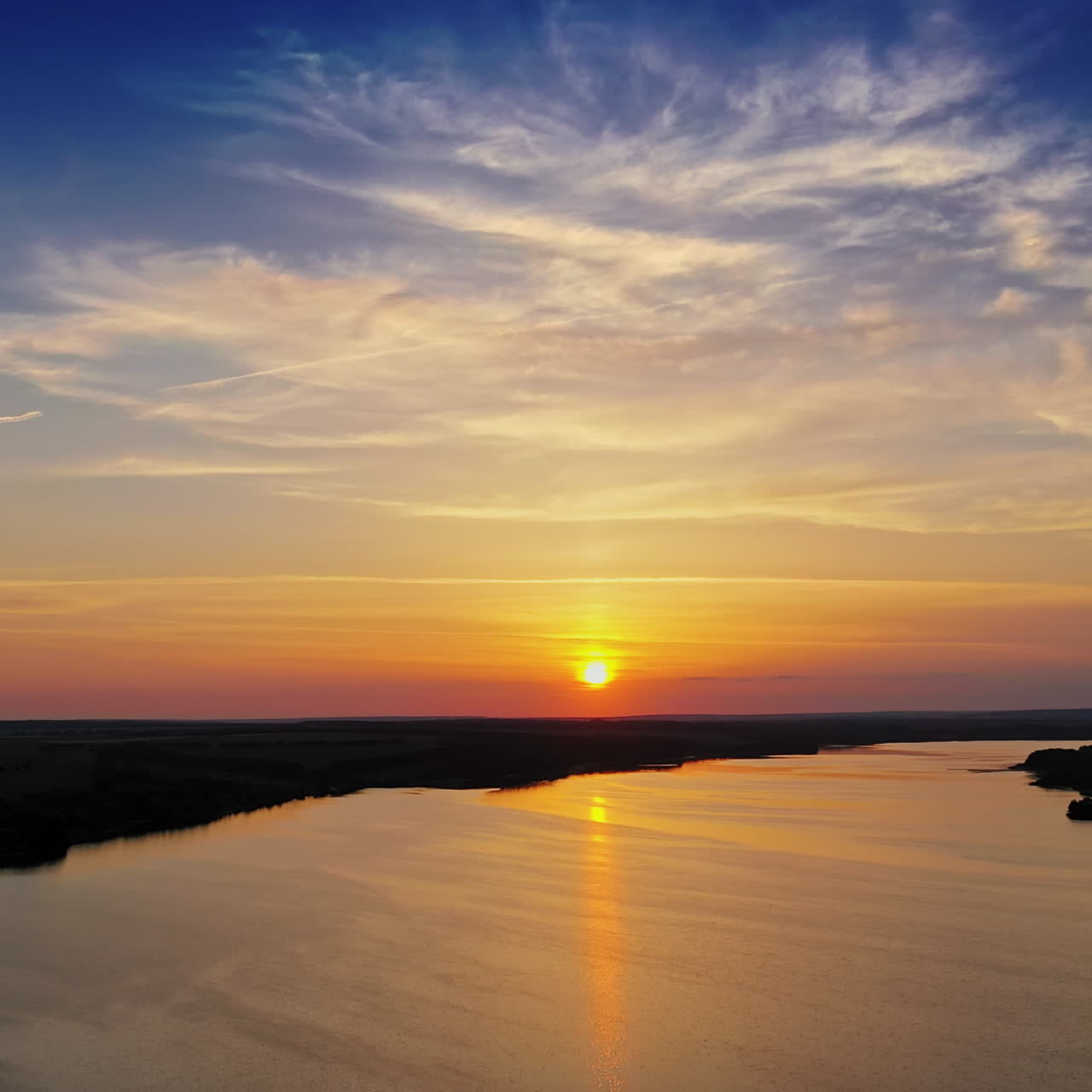 Amazing view on the river at sunset. Flight over the water under evening sky. Natural environment outdoors.