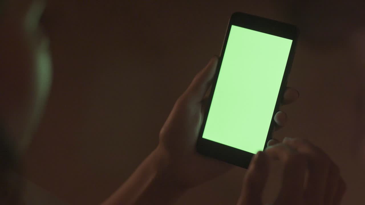 Persona que utiliza un teléfono inteligente por la noche