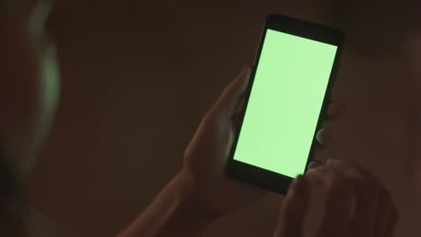 persona que utiliza un teléfono inteligente por la noche