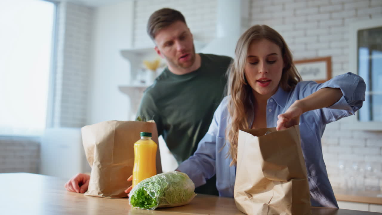 Couple putting shoppings kitchen table arrived from grocery store home closeup