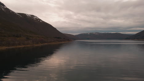 Cloudy-Sky-Reflections-On-Calm-Waters-Of-Nordfjorden-In-Kvaloya-Island,-Norway