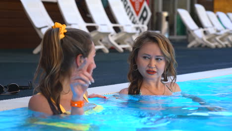 dos mujeres relajándose en una piscina