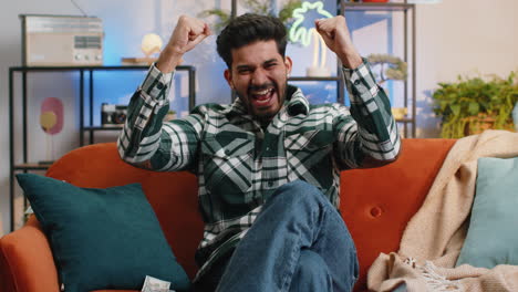 man celebrating on couch